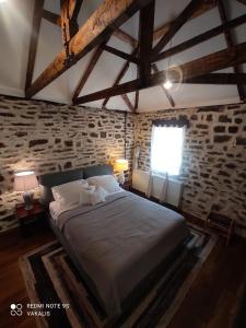 una camera con un grande letto in un muro di mattoni di Villa Vakalis a Ioannina