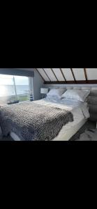 The Lifeboat & Seaview Terrace في سكيريز: سرير بشرشف ووسائد بيضاء في غرفة النوم