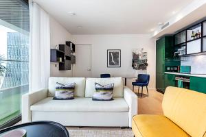 a living room with a white couch and a table at Canary Wharf City Escape 1-Bed Apartment in London