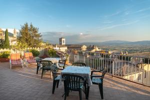 a patio with tables and chairs on a balcony at Hotel Umbra in Assisi