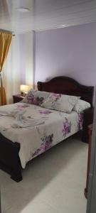 een slaapkamer met een bed met paarse bloemen erop bij Du-house in Filandia