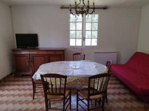 ein Esszimmer mit einem Tisch, Stühlen und einem Sofa in der Unterkunft Bienvenue en sud gironde in Villandraut