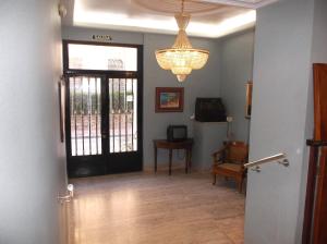 サンティアゴ・デ・ラ・リベラにあるHotel Lidoの黒いドアと椅子、シャンデリアのある廊下