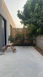 un patio con mesa de picnic y banco en סוויטה פרטית ברמת צבי, en Temarah