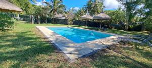 una piscina junto a una casa con patio en Clair de Lune - Private 2 Bedrooms Beachfront Villa, en Trou d'Eau Douce