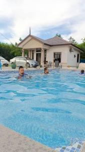 a group of people swimming in a swimming pool at Rumah Armand 3 Bedroom with Swimming Pool Pengkalan Balak Tg Bidara Masjid Tanah Melaka in Masjid Tanah