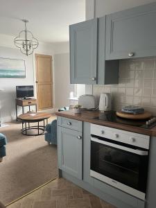 a kitchen with white cabinets and a stove top oven at Seascape in Lynton