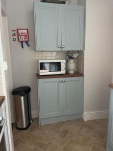 a kitchen with a counter with a microwave and a stool at Seascape in Lynton