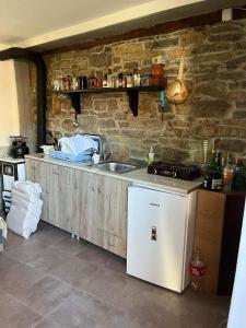 a kitchen with a sink and a stone wall at selo Paklestica in Pirot