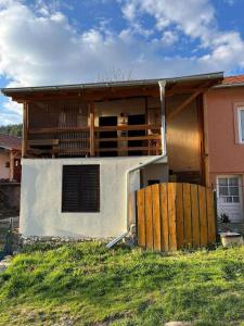 a house with a porch and a fence in front of it at selo Paklestica in Pirot