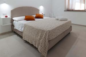 una camera da letto con un grande letto con cuscini arancioni di Al Chiaro di Luna Luxury Suites AMALFI COAST a Vietri