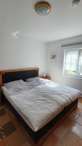a large bed in a bedroom with a window at Ferienhaus Marleen in Pritzier