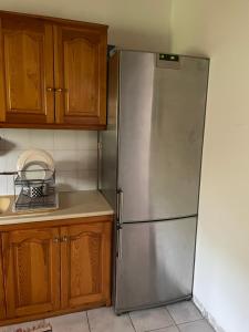 a stainless steel refrigerator in a kitchen with wooden cabinets at Παραθαλάσσια κατοικία στην παραλία Κατακόλου in Pýrgos +16 photos