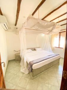 een slaapkamer met een bed met een klamboe bij Harbour Key Cottages - House 19 in Malindi