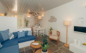 sala de estar con sofá azul y mesa en Villa Glaros, en Platis Yialos Sifnos