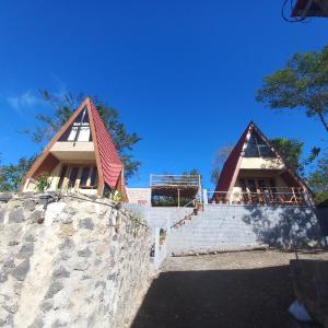 two peaked roofs on top of a stone wall at Agora Home in Wonosobo