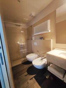 bagno con 2 lavandini, doccia e servizi igienici di Le Case Cavour a Ravenna
