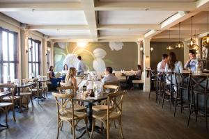 a dining room with people sitting at tables at Delamar Southport in Southport