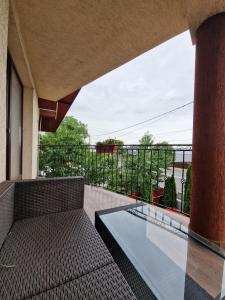 Dumbrava RoşieにあるCandy Pensiune&Restaurantのバルコニー(ベンチ、ガラスのテーブル付)