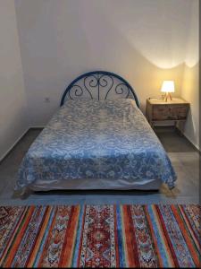 a bedroom with a bed and a table with a lamp at Traditional Stone Cottage in Özdere