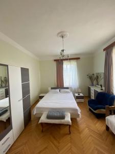 ein Schlafzimmer mit einem großen Bett und einem blauen Stuhl in der Unterkunft Family Guest House Marso in Ssatschcheri