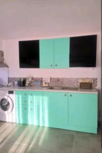 uma cozinha com armários azuis e uma máquina de lavar roupa em Traditional Stone Cottage em Özdere