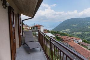 une chaise sur un balcon avec vue sur les montagnes dans l'établissement B&B La Bouganville, à Vigolo