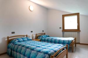 Cette chambre comprend 2 lits et une fenêtre. dans l'établissement B&B La Bouganville, à Vigolo