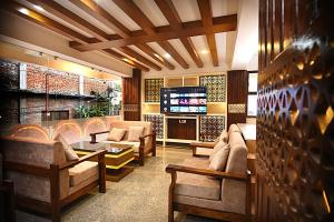 a living room with couches and a tv at Divine Kathmandu Hotel in Kathmandu