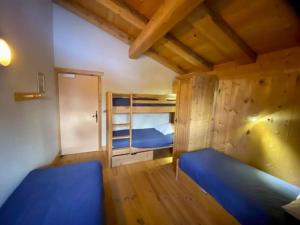 a bedroom with two bunk beds and a wooden wall at Gîte La Loriaz in Vallorcine