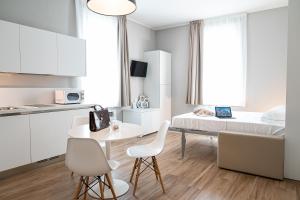 a room with a bed and a table and chairs at Villa Tosati in Monza