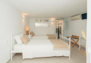 Habitación blanca con cama blanca y escritorio. en Villa Glaros, en Platis Yialos Sifnos