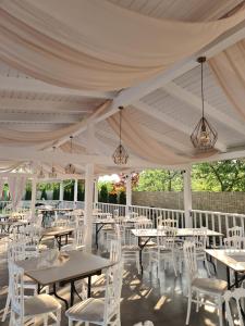 a white tent with tables and white chairs at Candy Pensiune&Restaurant in Dumbrava Roşie