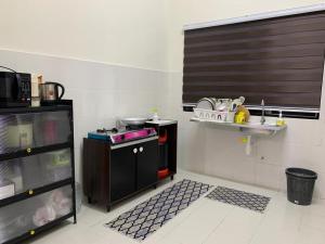 a small kitchen with a stove and a shelf at Juwita&Arjuna Homestay Teluk Senangin 