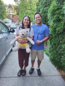a man and a woman holding a teddy bear at Sunshine and Wine Loft in Penticton