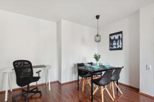 a dining room with a black table and chairs at Charming 60m² with King Bed, Kitchen, Netflix and Workspace with 1000 Mbit/s in Wiesbaden