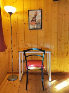 a desk with a chair and a lamp in a room at La Casa del Busso in Boccioleto