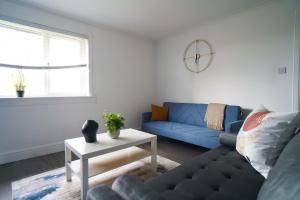 a living room with a blue couch and a table at Dunalastair Apartment in Glasgow