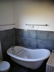 a white bath tub in a bathroom with a toilet at Paradise Beach House in Clareport