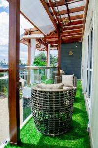 d'un balcon avec une chaise en osier sur la pelouse. dans l'établissement Blueberry Villas, à Eldoret
