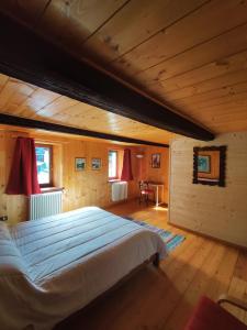 a bedroom with a large bed in a wooden room at La Casa del Busso in Boccioleto