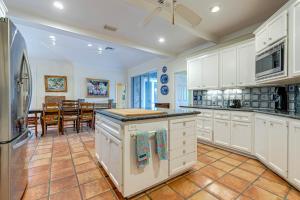 a kitchen with white cabinets and a dining room at Indian Harbor Haven in Vero Beach