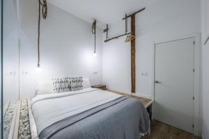 biała sypialnia z łóżkiem i białą ścianą w obiekcie Apartamento espléndido y céntrico w Madrycie