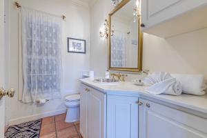 a bathroom with a sink and a toilet and a mirror at Indian Harbor Haven in Vero Beach