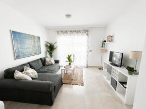 uma sala de estar com um sofá e uma televisão em TOP APARTMENT MANILVA La DUQUESA LUIS DE SABINILLAS WITH SWIMMING POOL AND PRIVATE GARDEN em San Luis de Sabinillas