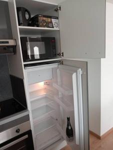 een keuken met een koelkast, een magnetron en een koelkast bij Maison totalement rénovée. in Fécamp