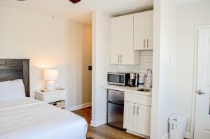 a bedroom with a bed and a kitchen with a microwave at Inn at Gulf Place 313 in Santa Rosa Beach