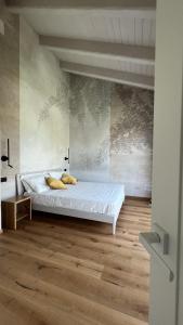 a bedroom with a white bed and a wooden floor at Casa Vola Bisalta in Cuneo