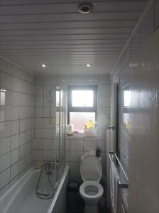 a bathroom with a toilet and a tub and a window at 5 Bedroom House ,by the Marmara Sea in Gemlik