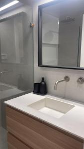 een badkamer met een witte wastafel en een spiegel bij סוויטה פרטית ברמת צבי in Temarah